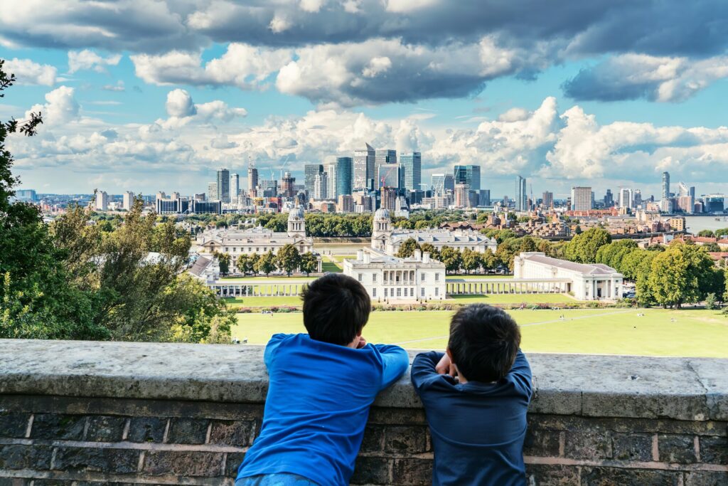 Two boys overlooking Canary Wharf and the rest of London from Greenwich Observatory.